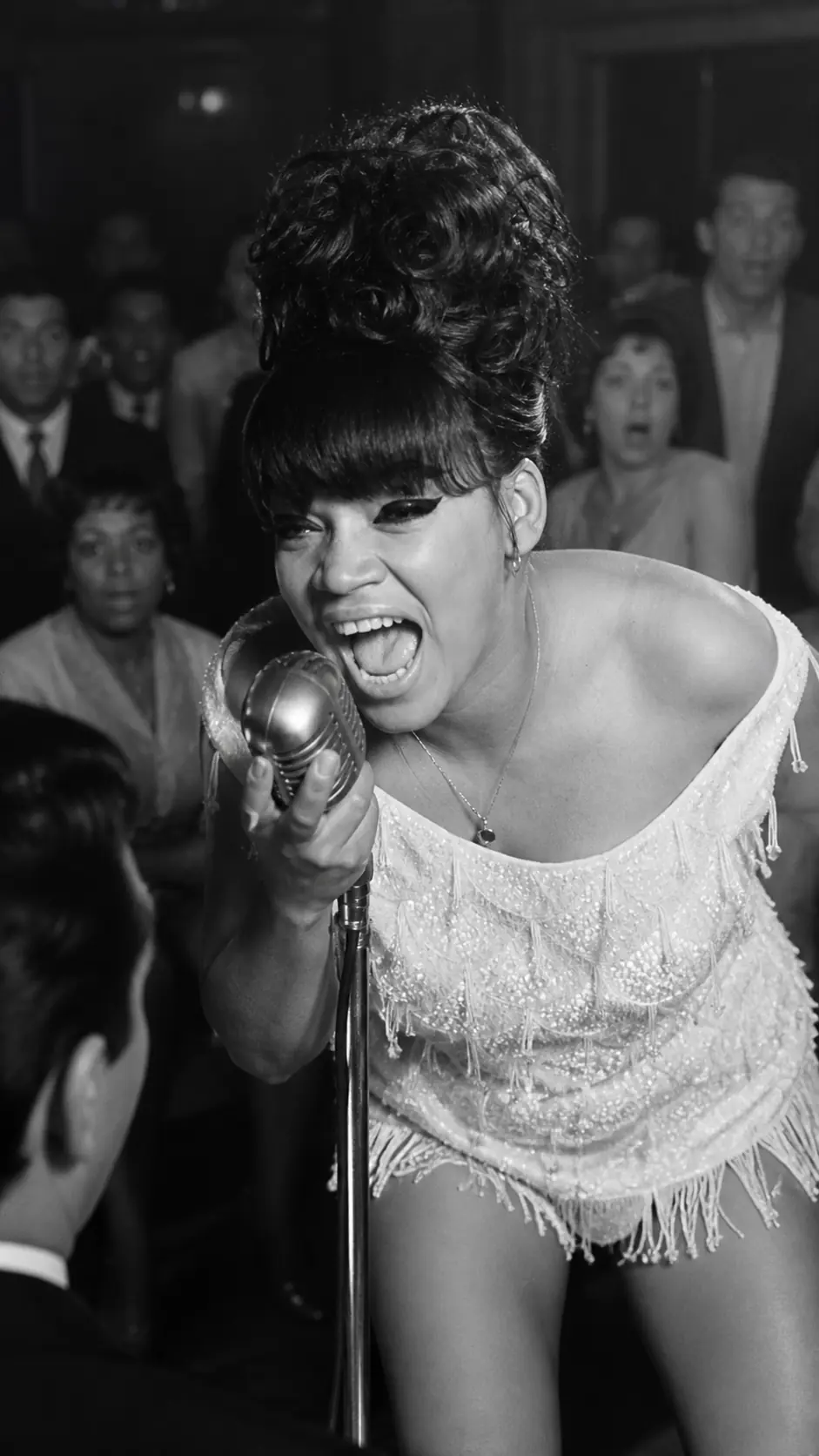 Recreación artística de La Lupe cantando con intensidad ante un micrófono
